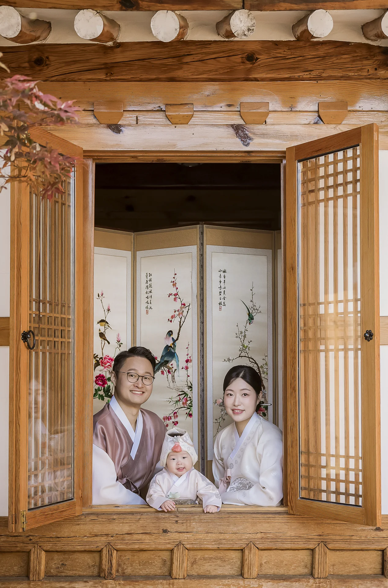 한옥 창문 너머로 담은 아빠·엄마·돌복 아기의 3인 가족사진